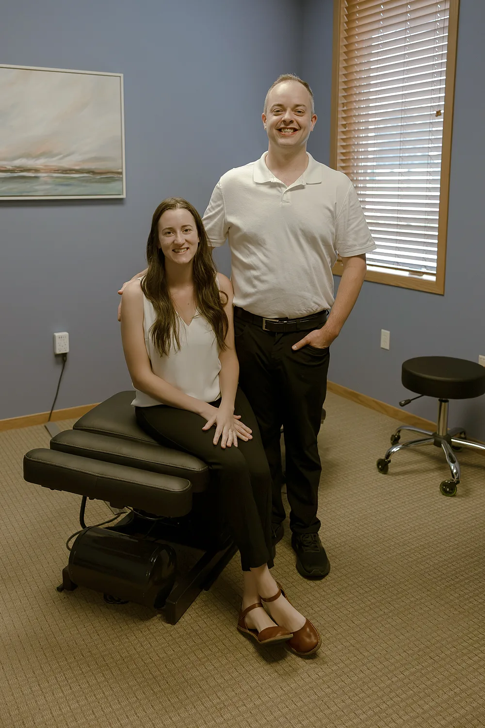 Dr. Moriah Severance and a colleague beside an adjusting table in a treatment room